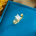 Close-up view of an elegant gold-tone adjustable ring with a large rectangular crystal - Sugar Cube Style (703) / Gold