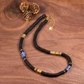 Detailed view of a vintage copper alloy and natural coconut shell necklace on wood - Gold Style (5)
