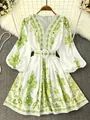 Detailed view of white V-neck dress with green bohemian floral print and matching belt. - S / Top And Bottom / Avocado Green