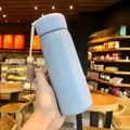 Close-up view of a pastel purple insulated water bottle featuring a decorative tassel. - Large / 400ml Size / Gray