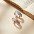 Detail view of luxury rose gold open rings with turquoise and violet stones on a book - Adjustable Open / Champagne Gold (Purple Rhinestone)