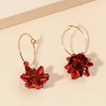Dettaglio ravvicinato di orecchini a cerchio con fiocco rosso metallizzato per Natale - Stile Cerchio Fiocco Rosso