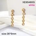 Close-up of gold-plated stainless steel long earrings with five sparkling white crystals - White