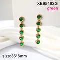 Detail view of gold-tone stainless steel drop earrings with five green round stones - Green