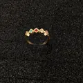 Vista macro dettagliata di un anello dorato vintage con piccole pietre di zircone colorate. - Stile Geometrico con Strass Multicolore (Oro)
