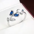 Detail view of a silver leaf-shaped ring with marquise blue stones in a gift box - Silver & Blue