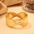 Elegante brazalete de aleación dorado con forma de onda irregular y acabado pulido - Lazo de Borde Retorcido (As0118)