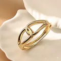 Elegante brazalete de aleación dorado retorcido irregular con diseño de puño de resorte - Anillos Entrelazados (As0130)