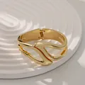 Brazalete irregular de aleación dorada con apertura de resorte y acabado pulido fino - Estilo de Ala Hueca (As0048)