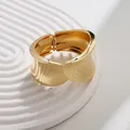 Brazalete moderno de aleación dorada con resorte y acabados lisos y martillados - Brazalete de Hoja con Patrón Asimétrico (As0083)