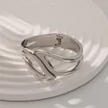 Brazalete moderno de aleación plateada con diseño irregular y apertura de resorte - Brazalete Calado de Alas (As0049)