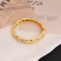 Elegante brazalete de aleación dorado con ondas irregulares y apertura de resorte. - Redondo con Textura (As0160)