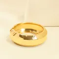 Brazalete grueso geométrico de aleación dorada con un elegante diseño de apertura lateral. - Redondo Geométrico (As0163)