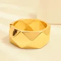 Elegante brazalete geométrico dorado con un moderno diseño de bisagra irregular - Geométrico Romboidal (As0167)