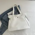 Large white canvas tote bag with drawstring detail on denim jacket background - White