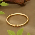Close-up detail view of an ancient matte gold open cuff bracelet with lotus bud ends. - Lotus Bud Style (SZ00222) / Adjustable Open / Gold