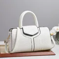 Elegant white crocodile texture handbag with top handle and shoulder strap in studio setting - White
