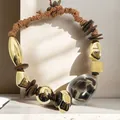 Bohemian necklace with leopard print bead, wood discs, and golden metallic accents. - Style (X-868) / Brown