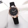 Primer plano de reloj de mujer con esfera de cielo estrellado, strass y correa de cuero negro - Negro