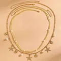 Stilvolle goldene mehrlagige Taillenkette im Boho-Stil mit Seesternen und Perlenanhängern - 79 KC-Gold Ozean Perle Mehrlagig (WG-0873)