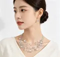 Close-up of Bohemian multi-layer crushed stone necklace and earrings on an Asian model. - White