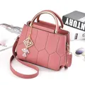 Elegant pink fashion handbag featuring geometric stitching detail and metal top handles - Dusky Pink