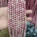 Detailed macro shot of 8mm natural pink rhodonite stone beads for jewelry making - Grade Ab Mahogany Grain/rose Stone / 8mm