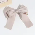 Elegant champagne colored bow hair clip featuring shimmering silver metallic wire edges - Khaki