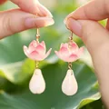 Boucles d'oreilles lotus élégantes avec pétales en émail rose et perles blanches d'eau. - Boucles D'oreilles Lotus Rose
