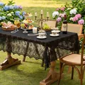 Elegante tovaglia in pizzo floreale nero esposta su un tavolo da pranzo in legno in giardino - 135*260cm / Floreale Segreto-Nero