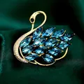 Elegante spilla a cigno dorata con cristalli blu intenso e strass luminosi - B592