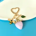 Mignon porte-clés doré en forme de cœur avec pendentif fraise rose, abeille et détail de feuille - Gelée Nuage Fraise Rose