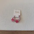 Gros plan d'élastiques à cheveux étoiles roses avec dégradé bonbon sur un support cartonné - Élastique Étoile Magenta
