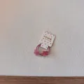 Détail d'un élastique à cheveux en forme d'étoile rose pailletée pour enfants sur carte - Élastique Étoile Mauve