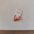 Vue détaillée d'un élastique rose avec des breloques en forme d'étoile orange - Élastique Étoile Rouge Orangé