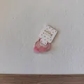 Vue détaillée d'élastiques à cheveux roses en forme de cœur sur une carte blanche. - Élastique Cœur Rose Clair