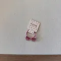 Gros plan d'un mignon élastique à cheveux cœur rose sur une carte à pois - Élastique Cœur Mauve