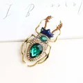 Vintage style beetle brooch featuring vibrant green crystals and elegant golden alloy finish - Green
