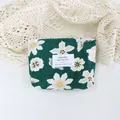 Close-up of a green floral corduroy cosmetic pouch with a white label on lace fabric. - Green Base White Floral