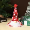 Detail view of a knitted Christmas gnome doll with white beard and glowing light feature - Sitting Forest Man / Red