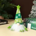 Detailed view of a green knitted Christmas gnome with a fluffy white beard and star hat. - Sitting Forest Man / Green