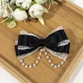 Close-up detail of a black satin Lolita bow hair clip with white lace and pearl tassels - Black