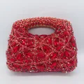 Gros plan d'une pochette de soirée incrustée de cristaux rouges et de strass brillants - Rouge