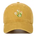 Detail van het witte bloemborduursel op een mosterdgele katoenen honkbalpet voor dames - Eén maat / Regular Fit / Geel
