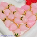 Close-up of several pink crystal strawberry-shaped pendants for DIY jewelry crafts - Resin Strawberry Pendant (S410)