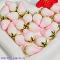 Detailed close-up of pink and white peach strawberry pendants in heart-shaped dish - Resin Strawberry Pendant (S411)