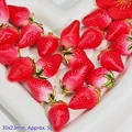 Detailed view of red strawberry pendants with gold leaf caps and 30x23mm size label - Resin Strawberry Pendant (S412)