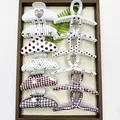 Close-up detail of various patterned hair claw clips featuring polka dots and grids. - Mixed Arc & Cross Patterns (12 Pieces)