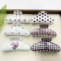 Macro view of six stylish Korean hair claw clips with varied patterns in a tray. - Mixed Arc Patterns (6 Pieces)