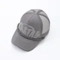 Close-up detail of grey street fashion trucker hat featuring puff-print letters and mesh back - Gray / Adjustable